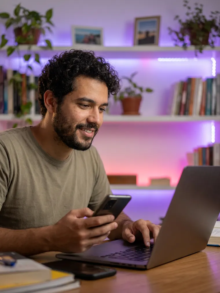 Dropshipper acompanhando os pedidos pelo laptop e pelo celular